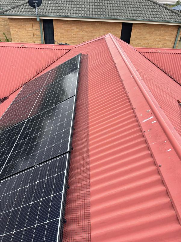 Solar Mesh installed on solar panels on red roof
